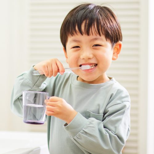 Smiling boy brushing his teeth